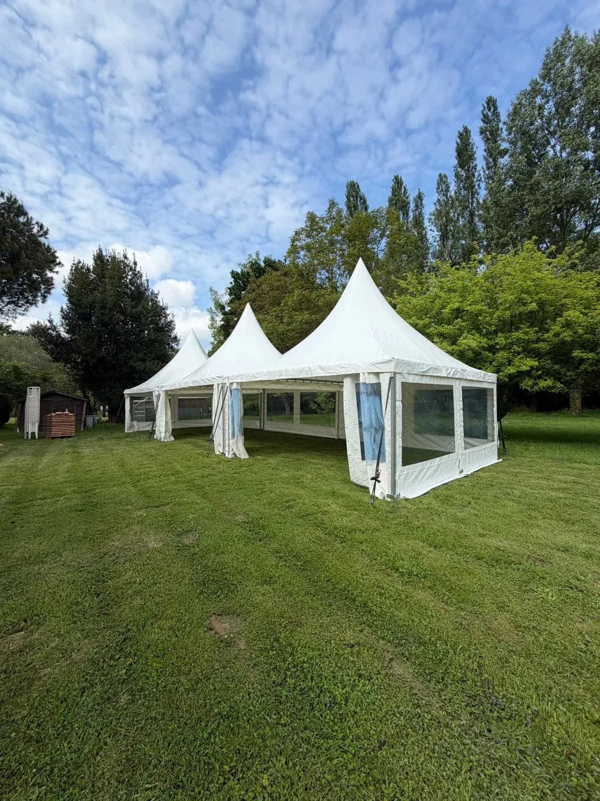Tentes pagodes blanches dressées dans un jardin arboré